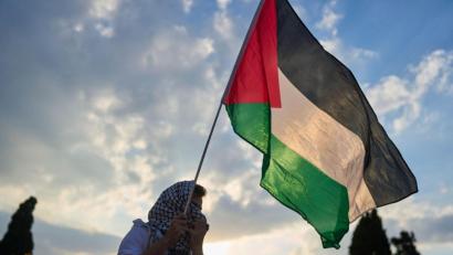 Bild: Petros Giannakouris/AP/dpa
Ein Demonstrant schwenkt eine palästinensische Flagge während einer Demonstration vor dem griechischen Parlament. (Archivbild)
