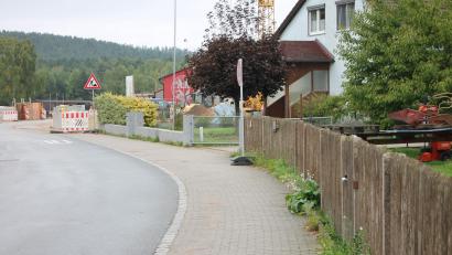Bild: Bernhard Piegsa
Schadhaft und in der Gestaltung nicht mehr zeitgemäß ist nach Auffassung der Gemeindeverantwortlichen der betongepflasterte Gehweg längs der Parksteiner Straße. Eine Erneuerung des Pflasters soll in die Städtebauförderung für die Arbeiten rund um das Gemeindezentrum (Hintergrund) einbezogen werden.