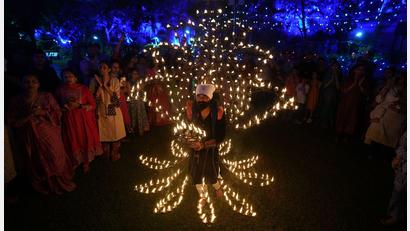 Bild: Ajit Solanki/AP/dpa
Ein Mann hält in einem mit Öllampen geschmückten Kostüm in der fünften Nacht von Navratri, dem Fest der neun Nächte, das Aarti-Ritual ab.