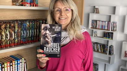 Bild: rpp
Büchereimitarbeiterin Renée Rupprecht zeigt das Cover des berühmten Buches "Der Bibelraucher". Der Bestsellerautor Wilhelm Buntz wird im Oktober aus seinem biografischen Werk berichten.