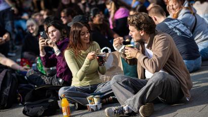 Bild: Moritz Frankenberg/dpa
Zahlreiche Menschen treffen sich am Küchengarten, einem Platz in Hannover, um Pudding mit Gabeln zu essen.
