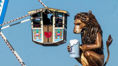 Bild: Peter Kneffel/dpa
Wiesn-Besucher fahren in einem Riesenrad auf dem 190. Münchner Oktoberfest an der Kulisse einen überdimensionalen Löwen mit Bierkrugs vorbei.