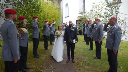 Bild: bk
Karolina Diebel und Patrick Müller laufen vor der Martinskirche in Kaltenbrunn durch das Ehrenspalier der Bundeswehr. Hauptmann Marco Thalmann (links) gratuliert mit einem Blumenstrauß.