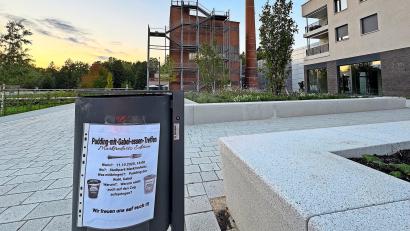 Bild: Matthias Bäumler
An einem Müllkübel im Auenpark hängt ein Plakat, das dazu einlädt, am 11. Oktober mitzumachen, wenn möglichst viele versuchen sollen, im Stadtpark mit einer Gabel Pudding zu essen.