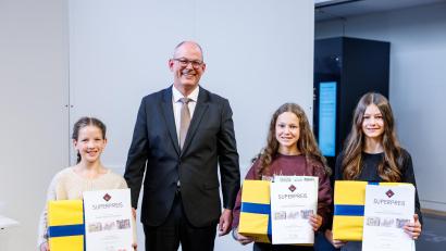 Bild: Matthias Balk/Bayerisches Staatsministerium für Unterricht und Kultus
Sie stehen im Auditorium im Deutschen Museums. Theresa Fehn vom Gymnasium Eschenbach (von links), Sophie Hefner vom Gymnasium Eschenbach und Lia Kraus vom Gymnasium Eschenbach haben den „Superpreis des Landeswettbewerbs - Experimente antworten“ gewonnen.