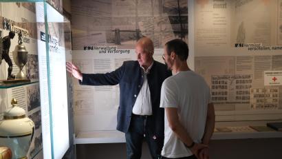 Bild: hba
Im Museum Flucht - Vertreibung - Ankommen erzählte Jochen Neumann (links) Ralph Würschinger Details zu den Ausstellungsstücken.