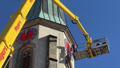 Bild: Gabi Schönberger
Spezialisten der Firma Bayreuther Turmuhren haben die restaurierten Zifferblätter und Zeiger wieder an den Turm der Kemnather Stadtpfarrkirche Mariä Himmelfahrt montiert. Ein Kran hievte die Arbeiter und die Einzelteile in der Hebebühne circa 40 Meter in die Höhe.