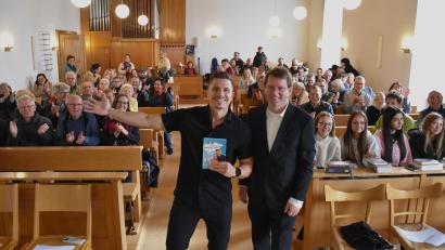 Bild: ubb
Chris Krömer (links) mit Pfarrer Andreas Kraft bekam nach seinem Vortrag und den Geschichten von sich und seiner Oma Lissi viel Applaus von den Teilnehmern und Teilnehmerinnen des diesjährigen Evangelischen Stiftlandtages.
