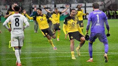 Bild: Arne Dedert/dpa
Die Dortmunder Spieler stürmen auf Elfmeter-Held Kobel zu.