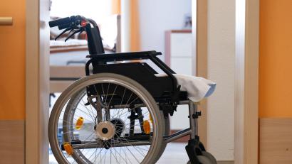 Symbolbild: Sebastian Kahnert/dpa
Eine 92-Jährige sitzt im Rollstuhl und wird aus einer Arztpraxis gefahren. Die Pflegerin stürzt mit dem Rollstuhl die Treppe hinunter. Der Sturz endet tödlich für die alte Frau.