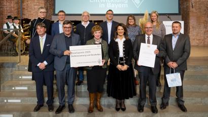 Bild: Tobias Hase/stmelf
Ministerin Manuela Kaniber mit den Preisträgern, den Bürgermeistern von Bad Neualbenreuth, dem Architekten sowie Vertretern des Vereins Badehaus Maiersreuth.