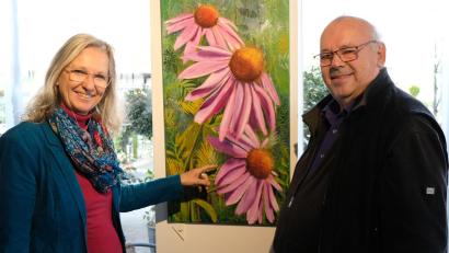 Bild: mab
Was sollte besser in die gärtnerische Landschaft eines Pflanzbetriebes, wie der Gärtnerei Ziereis passen, als ein farbenfrohes Gemälde einer "Echinacea purpurea"? Links die Künstlerin Marion Eschenbecher, rechts Gärtnermeister Hannes Ziereis, in dessen Räumen die Ausstellung stattfindet.