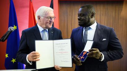 Bild: Bernd von Jutrczenka/dpa
Der frühere Fußball-Nationalspieler Gerald Asamoah (r) erhält von Bundespräsident Frank-Walter Steinmeier das Bundesverdienstkreuz.