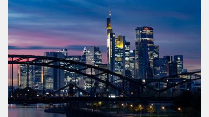 Bild: Boris Roessler/dpa
Die Lichter der Bankenskyline von Frankfurt leuchten in der Abendstimmung.
