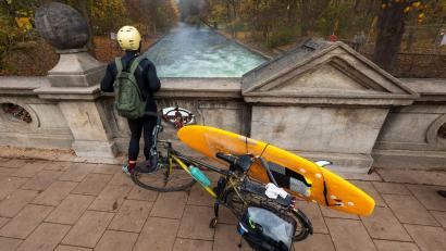 Bild: Peter Kneffel/dpa
Ein Mann mit einem Surfboard an seinem Fahrrad schaut von einer Brücke auf die - nicht mehr vorhandene - Eisbachwelle im Englischen Garten.