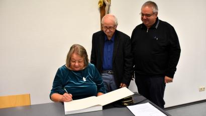 Bild: ubb
Rosa und Karl Prell (links) haben ihr Werk auf Wunsch auch bei der Buchpräsentation im Pfarrsaal Tirschenreuth signiert. Hans Stelzel von der Katholischen Erwachsenenbildung (rechts), der die Buchvorstellung organisierte, hat sich gleich ein Exemplar gesichert.