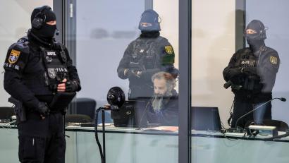 Bild: Jan Woitas/dpa
Der Angeklagte Taleb al-Abdulmohsen sitzt mit Handfesseln in einem kugelsicheren Glaskasten im Gerichtssaal.
