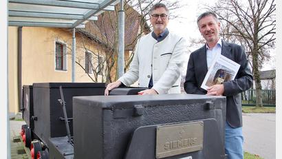 Bild: Thomas Dobler
Autor Michael Ernstberger (rechts) mit seinem neuen Buch und der Stullner Bürgermeister Hans Prechtl bei der Siemens-Grubenlok, die vor dem Feuerwehrhaus in Stulln an die Zeit des Flusspat-Bergbaus in der Region erinnert.