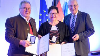 Bild: Timm Schamberger / Bayerische Staatskanzlei
Innenminister Joachim Herrmann (rechts) übergibt für Maria und Eduard Kunschir im Germanischen Nationalmuseum Nürnberg das Ehrenzeichen für Verdienste im Ehrenamt.