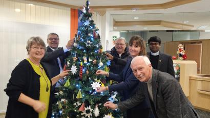 Bild: Stefanie Seidl
In der Neusorger Filiale der Raiffeisenbank Oberpfalz Nordwest eröffneten Raiffeisenbank-Mitarbeiterin Ingrid Heinl (von links), Caritas-Geschäftsführer Martin Kneidl, Kirchenpfleger Hans Richtmann, Cornelia Wöhrl (Assistenz der Geschäftsleitung) Pater Arul und Bürgermeister Peter König die Wunschsterne-Aktion.