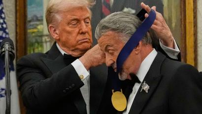 Bild: Julia Demaree Nikhinson/AP/dpa
US-Präsident Donald Trump hängt der Actionfilm-Ikone Sylvester Stallone eine Medaille um.