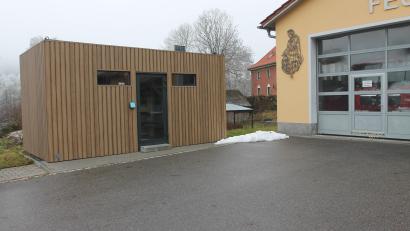 Bild: pi
Links neben dem Feuerwehrhaus der Container für den Dorfladen. Aber da herrscht Stillstand seit einem halben Jahr.