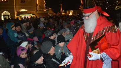 Bild: jr
Sankt Nikolaus (von den Pfadfindern) verteilt auf dem Stufen zum Rathaus Schoko-Nikoläuse an die Kinder.