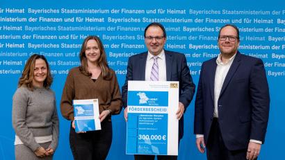 Bild: StMFH/Christian Blaschka
Martin Schöffel (rechts), Mitglied des Landtags und Staatssekretär, übergab den offiziellen Förderbescheid im Bayerischen Staatsministerium der Finanzen und für Heimat in Nürnberg. Empfänger waren (von links) die beiden Projektmanagerinnen Nina Schellkopf und Franziska Schwenk sowie Thomas Harmsen, Geschäftsführer von Oberpfalz-Marketing e. V.