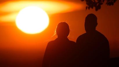 Bild: Julian Stratenschulte/dpa
Ein Paar bei Sonnenaufgang