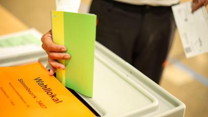 Symbolbild: Christoph Reichwein/dpa
Ein Mann wirft seine Stimmzettel in eine Wahlurne.