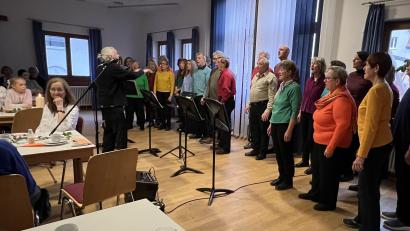 Bild: mma
Dorothea (sitzend, links) und Hans (Mitte, rotes Hemd) Bauer feierten jetzt ihren 140. Geburtstag mit dem Multi-Chor und für einen guten Zweck.