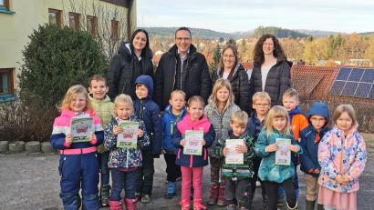 Bild: Portner
Die Teunzer Kinder und Leiterin Simone Kraus (links) freuen sich über das Abenteuerbuch, welches unter der Regie des Kinderhaus-Elternbeirates mit Vorsitzendem Martin Pflug, dessen Vorgängerin Simone Kraus und Teammitglied Elisabeth Birner (rechts) entstanden ist.