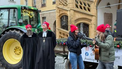 Bild: Petra Hartl
Während Diana Laden und Michael "Dandy" Dandorfer singen und spielen, schaut Regionalbischof Klaus Stiegler sinnend in den Himmel. Pfarrer David Scherf "bewacht" derweil den Weihnachtsbulldog der Erlösergemeinde.