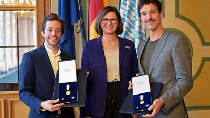 Bild: Malin Wunderlich/dpa
Landtagspräsidentin Ilse Aigner (CSU) zeichnet Tobias Krell und Florian David Fitz bei einem Nachholtermin mit dem Bayerischen Verfassungsorden aus.