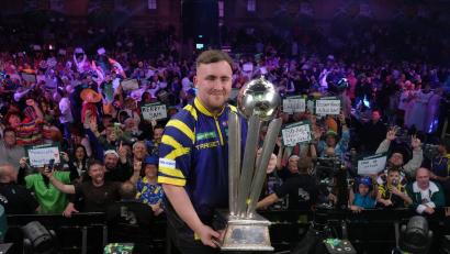 Bild: Dave Shopland/AP/dpa
Littler präsentiert zum zweiten Mal die WM-Trophäe.