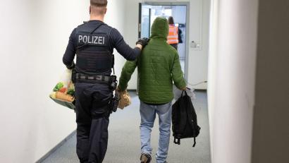 Bild: Boris Roessler/dpa
Ein Polizeibeamter bringt einen Mann zu einem Abschiebeflug nach Pakistan. (Archivfoto)