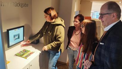 Bild: luk
Ausweis unter den Strichcodescanner halten, bis zu fünf Medien in ein gekennzeichnetes Feld legen und den Anweisungen am Bildschirm folgen: Judith Schliermann demonstriert Christine Schubert, Deborah Pregler und Bürgermeister Roman Schäffler (von links), wie Ausleihe und Rückgabe am Verbuchungsgerät funktionieren.