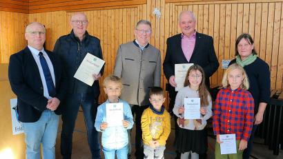 Bild: bsc
Das vielfältige ehrenamtliche Engagement zahlreicher Bürger prägt das Leben in der Gemeinde Friedenfels. Im Bild die Geehrten Hans Lenk (hinten, Zweiter von links) und Gottfried Härtl (hinten, Zweiter von rechts) mit den ausgezeichneten Kindern (vorne) sowie Erstem Bürgermeister Oskar Schuster (hinten, Mitte), Zweitem Bürgermeister Christian Bischof (links) und Dritter Bürgermeisterin Lisa Rauh.