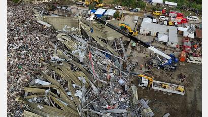 Bild: Jacqueline Hernandez/AP/dpa
Die Einsatzkräfte suchen unter anderem mit einem Kran in den Abfall-Massen.