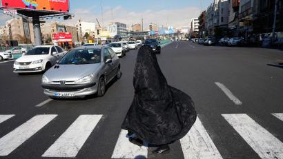 Bild: Vahid Salemi/AP/dpa
Alltag in Teheran:  Verschleierte Frau überquert Kreuzung im Zentrum
