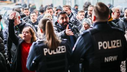 Bild: Christoph Reichwein/dpa
Aufgebrachte Kunden diskutieren vor der Sparkassenfiliale mit Polizeibeamten (Archivfoto)