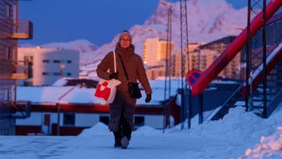 Bild: Evgeniy Maloletka/AP/dpa
Eine Frau geht bei Sonnenuntergang auf einer Straße in Nuuk.