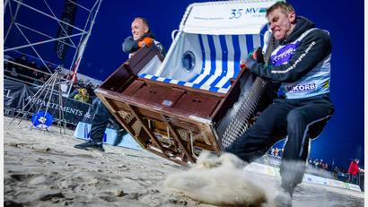 Bild: Jens Büttner/dpa
Sie geben alles: Das Team „Quad Safari Usedom“ mit Phillip Schmidt (l) und Finley Liemen (r) gewinnt den Finallauf bei der 18. Strandkorb Weltmeisterschaft auf der Insel Usedom mit einer neuen Weltrekordzeit von 4,56 Sekunden. Die Zweierteams müssen bei dem Wettkampf einen etwa 60 Kilogramm schweren Strandkorb über die 20 Meter lange Strecke über den Ostseestrand ins Ziel schleppen.