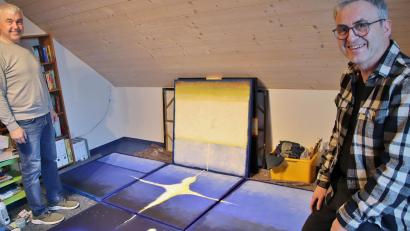 Bild: Thomas Dobler
Künstler Markus Pleyer (rechts) und Kirchenpfleger Günter Schießl in Pleyers Atelier in Wolfring. Das Fastenbild besteht aus fünf quadratischen Gemälden, jedes einen Quadratmeter groß. Die Holzrahmen der einzelnen Tafeln werden verschraubt, dann kann das kreuzförmige Kunstwerk in der Albertus-Magnus-Kirche in Fensterbach aufgehängt werden.