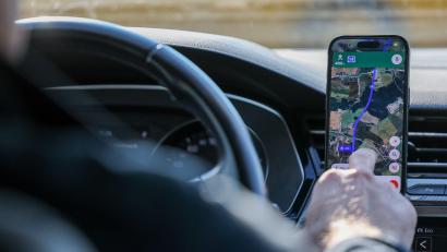 Bild: Jan Woitas/dpa
So ist es derzeit erlaubt: Das Handy steckt in der Halterung und wird nur kurz vom Fahrer beachtet. (Symbolbild)