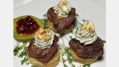 Bild: Michael Schiffer
Die Hasenfilets mit Calvadoskäse werden zum Servieren auf rundes Toastbrot platziert und mit Kresse bestreut.