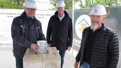 Bild: kro
Bürgermeister Roman Schäffler (links) setzt die Blechdose in das Mauerwerk ein. Bei diesem Akt mit dabei waren auch Johannes Fischer vom Planungsbüro Fischer (Mitte) aus Marktredwitz sowie Josef Reger von der Baufirma Reger-Bau aus Vohenstrauß.