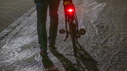 Bild: Armin Weigel/dpa
Ein Mann schiebt sein Fahrrad auf einer vereisten Straße.
