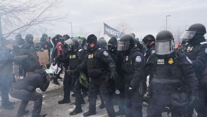 Bild: Adam Gray/AP/dpa
Bundesbeamte der Einwanderungsbehörde ICE sind hier bei einer Demonstration in Minneapolis zu sehen.