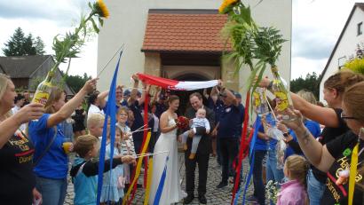 Bild: bk
Das vor Glück strahlende Brautpaar mit Söhnchen Leopold beim Durchschreiten des Ehrenspaliers.